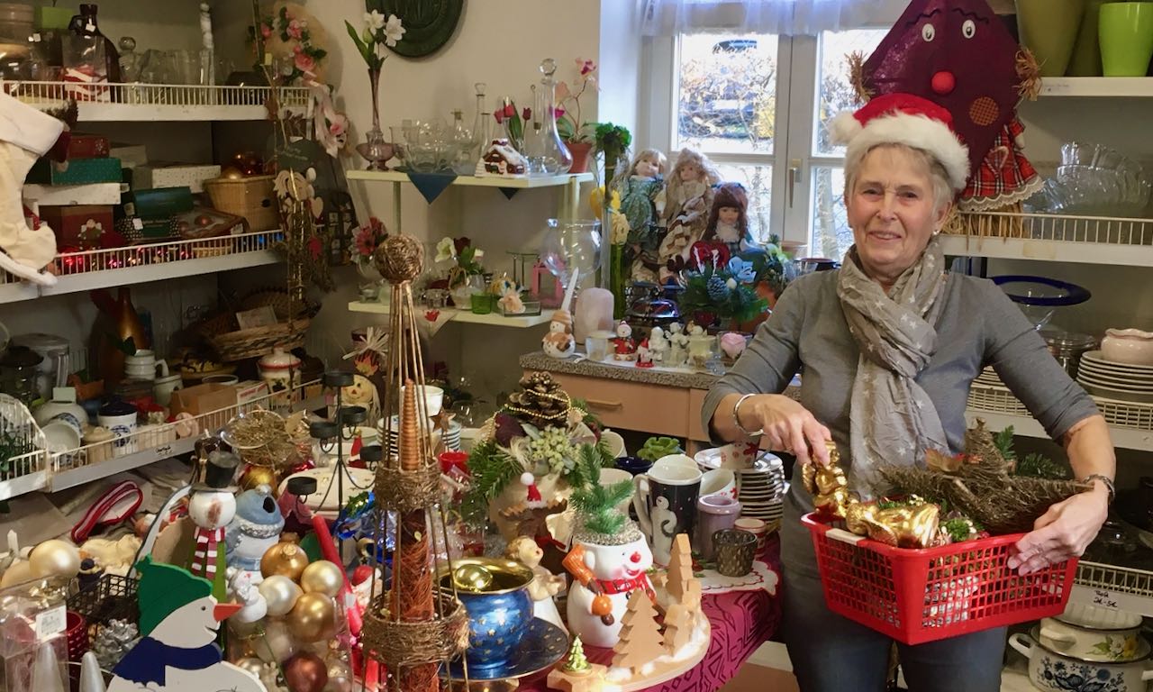 Gabi Stölting vom FAIRKAUF-Laden-Team befüllt einen Einkaufskorb mit Advents- und Weihnachtsartikeln. | Foto: Corinna Jacobi / Caritas