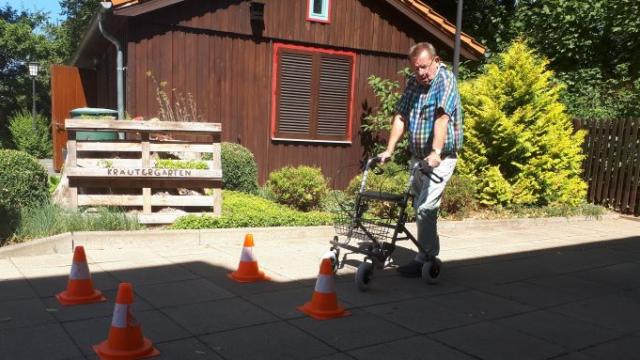 Siegfried Storch von der Verkehrswacht demonstriert die Durchfahrt einer engen Straße mit einem Rollator. | Fotos: Caritas Siegfried Storch von der Verkehrswacht demonstriert die Durchfahrt einer engen Straße mit einem Rollator. | Fotos: Caritas
