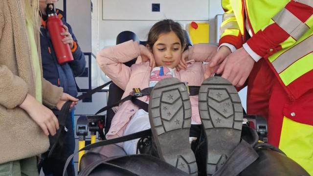 Das Probeliegen im Rettungswagen machte viel Spaß, richtiges Anschnallen muss geübt sein. | Foto: Caritas Das Probeliegen im Rettungswagen machte viel Spaß, richtiges Anschnallen muss geübt sein. | Foto: Caritas